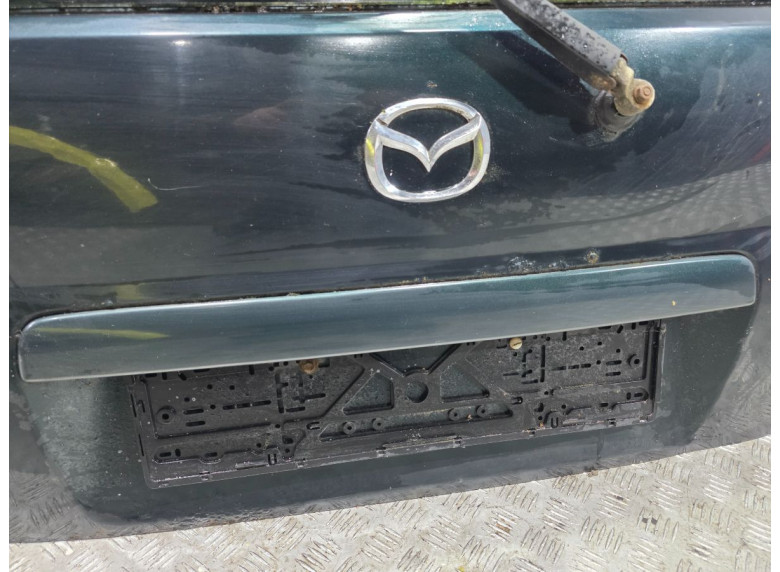 Накладка подсветки номера к Mazda Demio, 1999г.